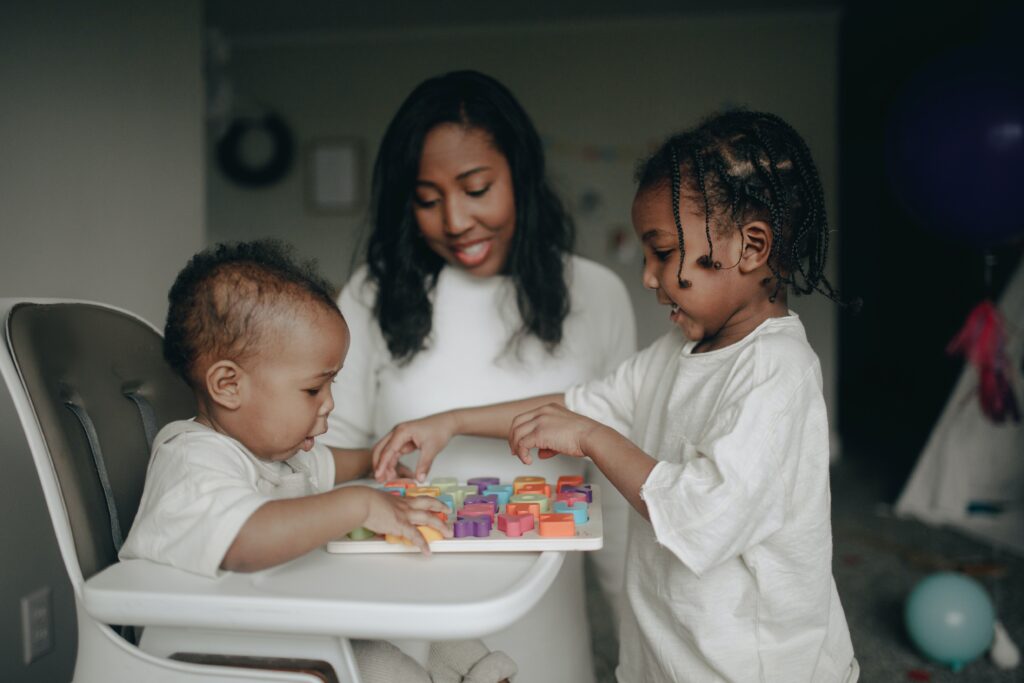 mother completing puzzle with baby and toddler