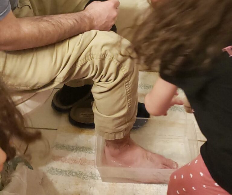 child washing father's feet for Maundy Thursday