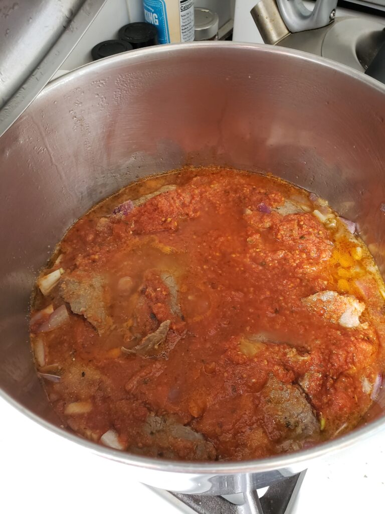 braciole in a pot with sauce