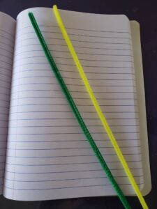 notebook with a yellow and green pipe cleaner